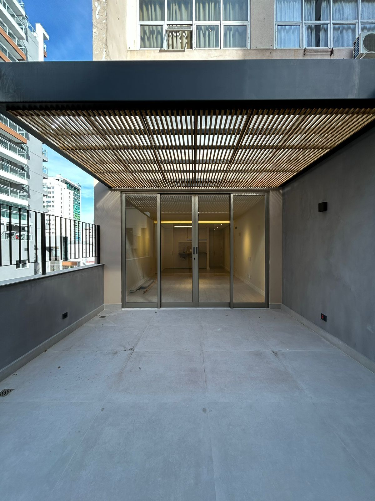 Terraço privativo sob pergolado do Studio Consolação